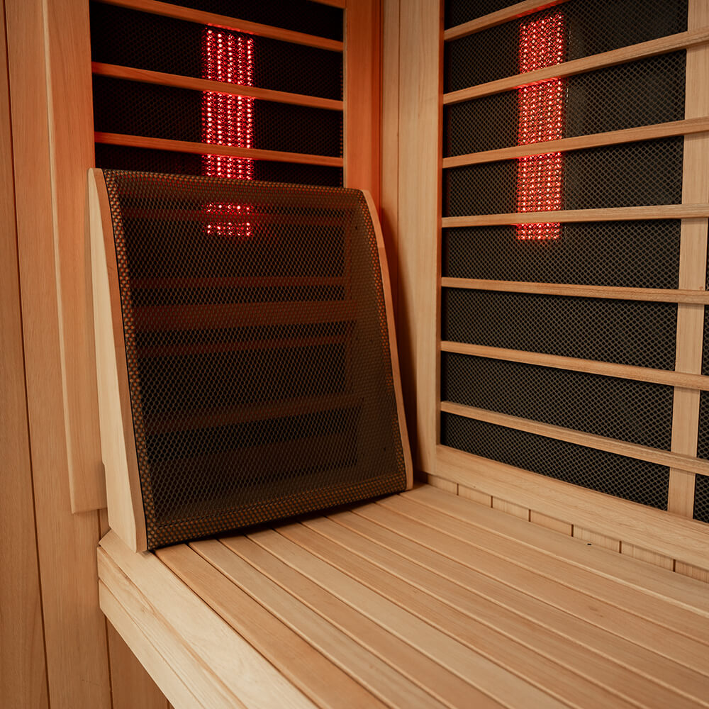 A wooden sauna interior with a mesh screen panel leaning against the bench, and red illuminated light bars visible through the slatted walls.