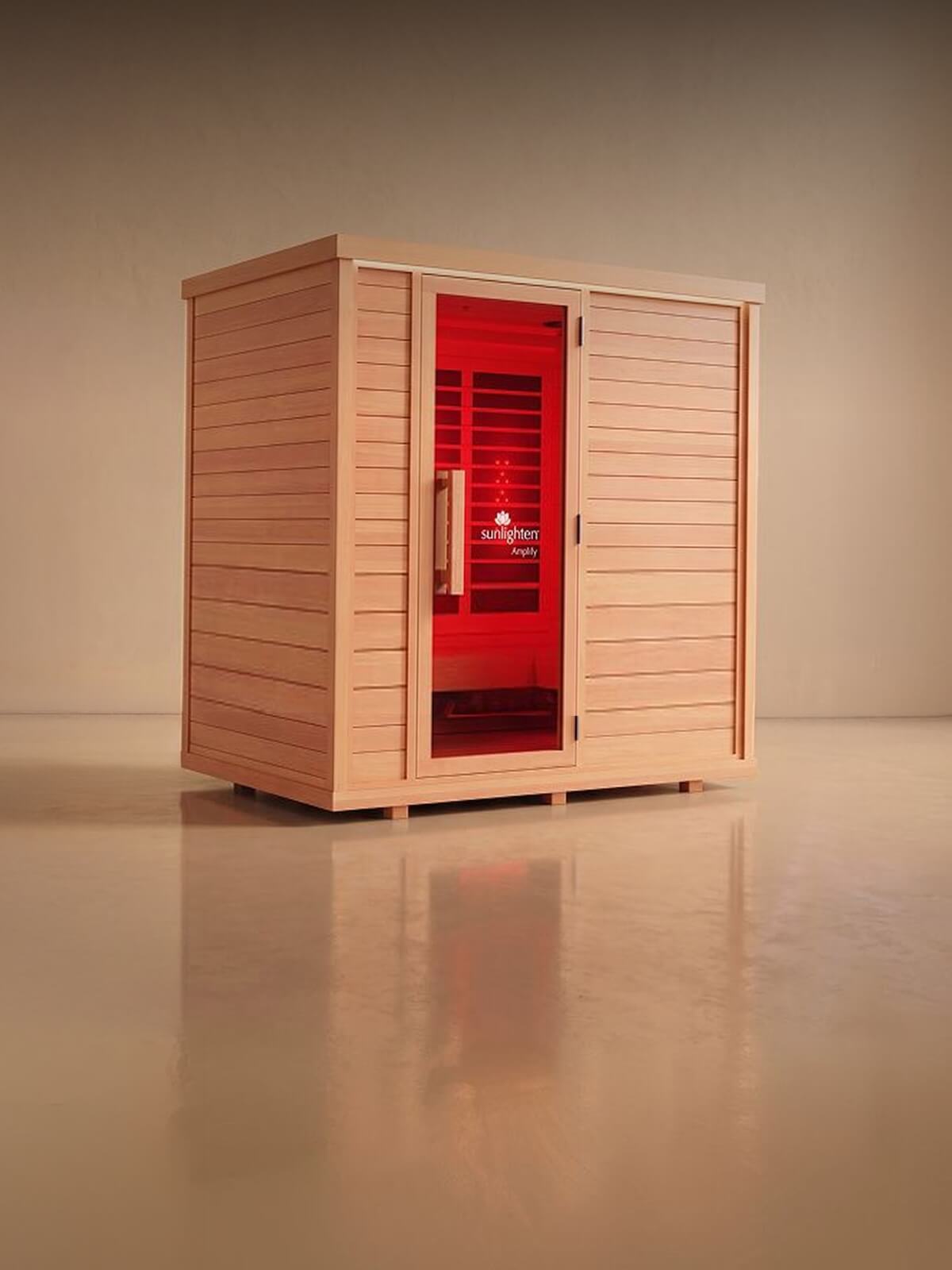 A wooden sauna cabin with a red illuminated interior, shown on a neutral studio background with a reflective floor.