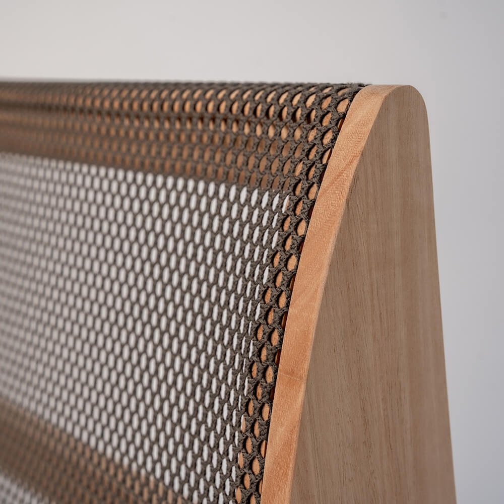 A closeup of a wooden backrest with CELLIANT fabric, featuring a natural light wood finish